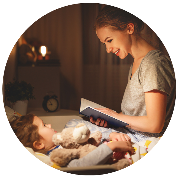 Eine Mutter, die einem Kind, das im Bett liegt, aus einem Buch vorliest.