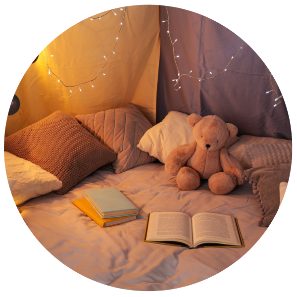 gemütliches Kinderbett am Abend mit Büchern und Lichterketten